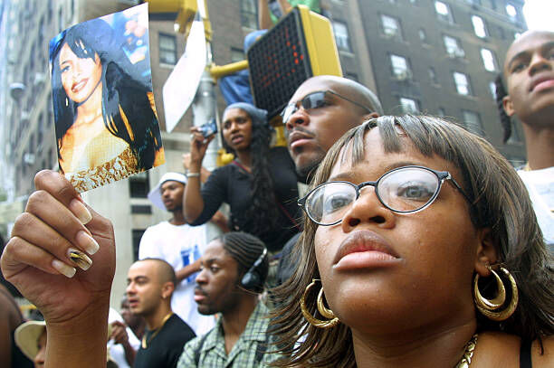 393921 02: Fans of R&B singer Aaliyah watch a horse-drawn carriage carry her coffin towards St. Ignatius Loyola Church August 31, 2001 during her funeral in New York City. The 22-year-old singer died August 25 in a plane crash in the Bahamas. (Photo by Mario Tama/Getty Images)