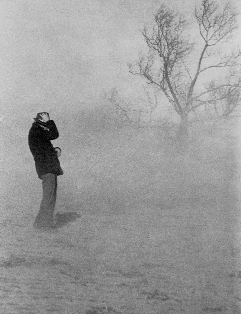 A man holding on his hat during a dust storm. Burlington, New Jersey, February 1938. (Photo by © CORBIS/Corbis via Getty Images)