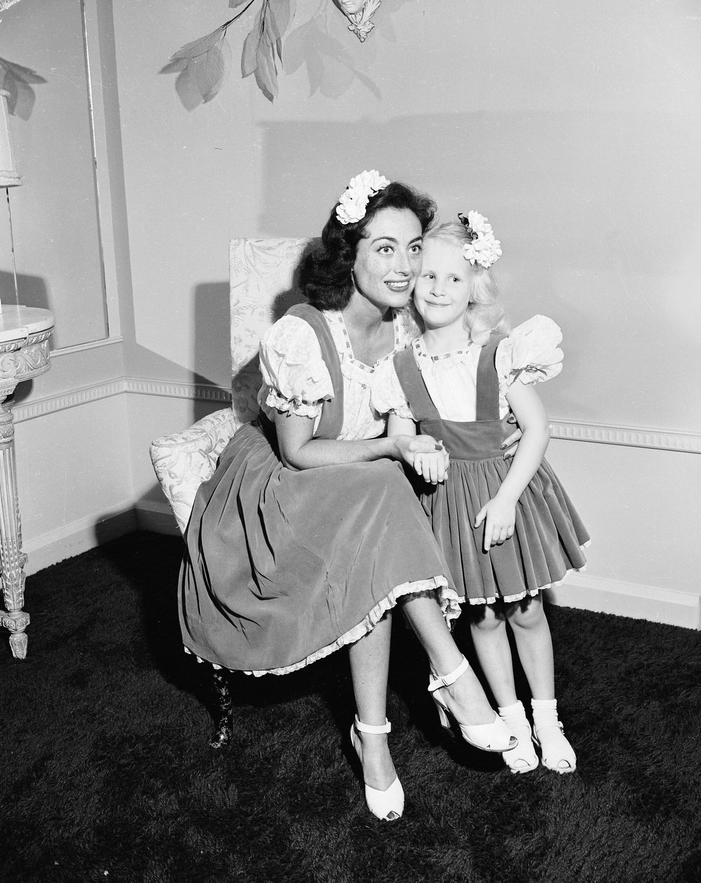 American actor Joan Crawford (1904 - 1977) hugs her adopted daughter Christina, wearing matching outfits, June 1944. (Photo by Gene Lester/Getty Images)