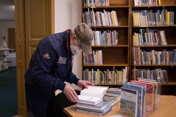 PRESOV, SLOVAKIA - APRIL 19: An unidentified man browses through the book in the regional Library of P. O. Hviezdoslav after it was re-opened under new COVID-19 measures allowing people to choose books directly from the open spaces of the library on April 19, 2021 in Presov, Slovakia. Slovakia has recorded over 374,000 cases of COVID-19 infections, over 11,000 deaths in total, in a population of 5.4 million residents. Certain shops, libraries, museums, hotels, Zoos, botanical gardens, swimming pools, and churches will be allowed to open their doors under strict regulations for people. Travel between regional districts will be allowed with a negative antigen or PCR test. (Photo by Zuzana Gogova/Getty Images)
