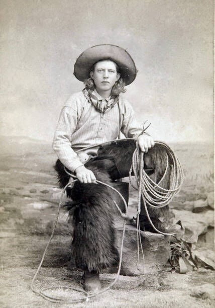 Cowboy Wearing Black Wooly Chaps, A Kerchief, Lariat In Hand, Spurs, Cowboy Boots, Holstered Revolver, And Great Cowboy Hat. Handsome Cowboy With Lariat. (Photo by C.D. Kirkland/Buyenlarge/Getty Images)
