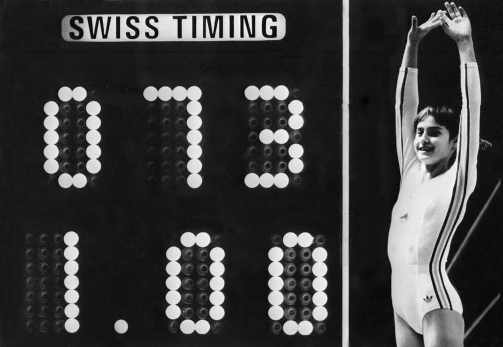 Rumanian champion Nadia Comaneci, aged 14, jubilates when scoreboard shows the perfect score of 10 during Olympic Games 19 July 1976 in Montreal after her acrobatic compulsory at uneven bars. She was awarded with ten points in two exercices and captured 3 gold medals (beam, uneven bars and general competition). Legendary gymnast, during her career Nadia Comaneci captured four Olympic gold medals (1976 : beam, uneven bars and general competition - 1980, beam) and was the first to score 10 in her discipline. / AFP PHOTO / -        (Photo credit should read -/AFP via Getty Images)